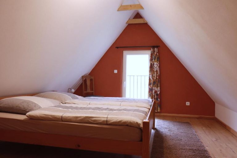 Waldzimmer mit Doppelbett und Waldblick im Ferienhaus mit Klavier in Alt Jabel
